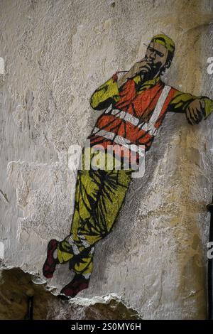 MAUSA VAUBAN, Musée d'Art urbain et de Street Art, forteresse de neuf-Brisach, France, Europe, fresque d'un ouvrier en gilet orange penché agai détendu Banque D'Images