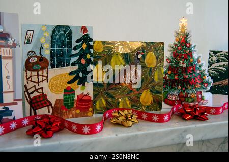 Cartes de Noël affichées sur la cheminée en marbre gris avec ruban rouge et noeuds recyclés. Banque D'Images