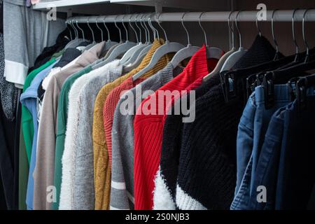 Gros plan de vêtements tricotés chauds féminins sur des cintres dans le placard Banque D'Images