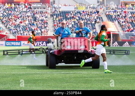 WINNIPEG, CANADA - 12 JUIN : les joueurs du Nigeria s'échauffent alors que la surface de jeu en gazon artificiel est traitée pour un match de la Coupe du monde féminine de la FIFA du Groupe d entre l'Australie et le Nigeria le 12 juin 2015 au Winnipeg Stadium à Winnipeg, Canada. Usage éditorial exclusif. Utilisation commerciale interdite. (Photographie de Jonathan Paul Larsen / Diadem images) Banque D'Images