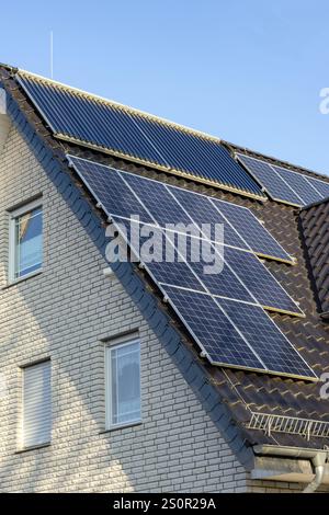 Toit d'une maison bifamiliale avec capteurs solaires et collecteurs à tubes à vide Banque D'Images