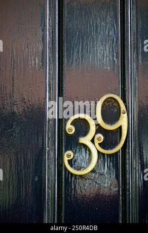 numéros de porte en laiton sur la porte peinte en noir worcester, angleterre Banque D'Images