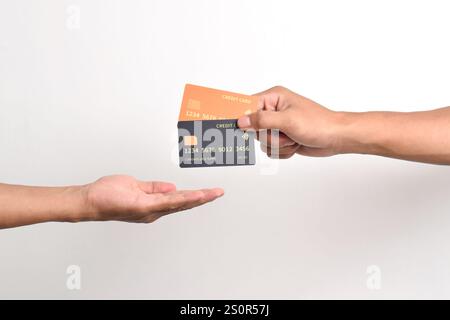 Main tenant deux cartes de crédit et l'autre main recevant isolé sur fond blanc. Banque D'Images