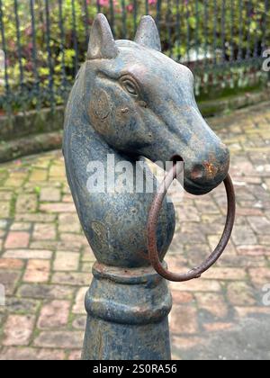 Un vieux poteau d'attelage de cheval en métal est montré dans le Garden District de la Nouvelle-Orléans, en Louisiane pendant la journée dans une vue verticale. Banque D'Images