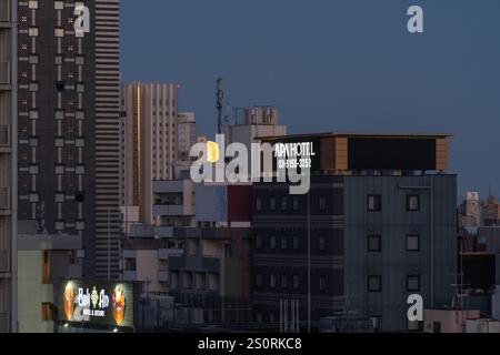 Tokyo, Japon - 15 décembre 2024 - vue de la lune jaune se posant derrière les gratte-ciel de Tokyo, Japon, au lever du soleil tôt le matin Banque D'Images