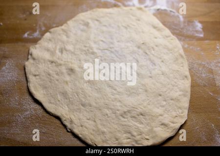 Pâte roulée plate sur une surface en bois farinée Banque D'Images