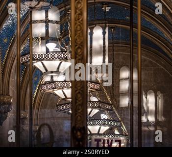 Vue rapprochée de lustres ornés suspendus à un plafond magnifiquement cintré, aux motifs complexes et à l'éclairage tamisé. Les showcas d'arrière-plan Banque D'Images