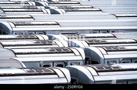 Vue aérienne de nombreux wagons de train garés étroitement ensemble, montrant leurs toits argentés et numéros distinctifs. L'image capture la Banque D'Images