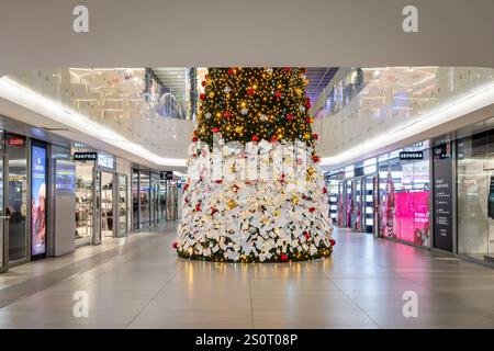 Sapin de Noël décoré de boules colorées et de lumières clignotantes. Rome, Italie - 27 décembre 2024 : arbre de Noël majestueux installé à l'intérieur de la gare Termini pour les vacances de Noël. Les gens expriment leurs souhaits à travers des notes attachées au sapin de Noël. Italie Copyright : xGennaroxLeonardix Banque D'Images