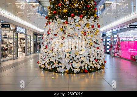 Sapin de Noël décoré de boules colorées et de lumières clignotantes. Rome, Italie - 27 décembre 2024 : arbre de Noël majestueux installé à l'intérieur de la gare Termini pour les vacances de Noël. Les gens expriment leurs souhaits à travers des notes attachées au sapin de Noël. Italie Copyright : xGennaroxLeonardix Banque D'Images