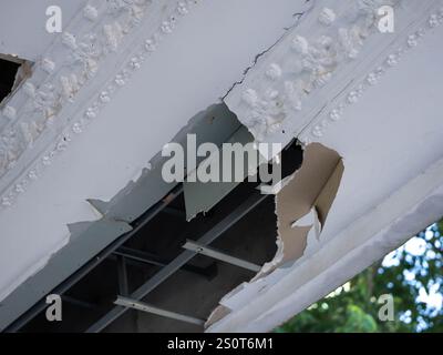 Les panneaux de plafond ont endommagé un grand trou dans le toit à cause d'une fuite d'eau de pluie. Concept de service et de réparation. Banque D'Images