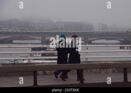 Londres, Royaume-Uni. 29 décembre 2024. Les gens marchent le long du pont de Waterloo en passant devant un horizon complètement obscurci de la City of London tandis que le brouillard épais descend sur la capitale. Crédit : Vuk Valcic/Alamy Live News Banque D'Images