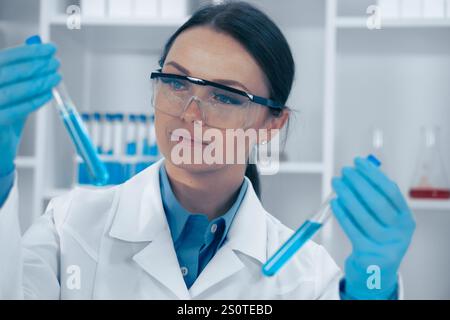 Dans un laboratoire de haute technologie, un scientifique dédié analyse des tubes à essai avec un équipement de pointe, ce qui stimule les innovations en biotechnologie et en soins de santé pour améliorer Banque D'Images