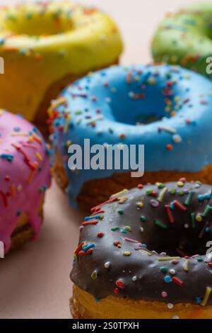 Délicieux beignets avec des saupoudrages colorés sur fond beige Banque D'Images