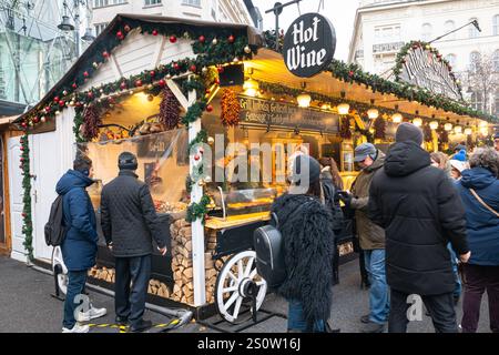 Les gens à un stand de vin à la célèbre et populaire foire de Noël à Vörösmarty Tér (place Vörösmarty) dans le centre de Budapest, Hongrie Banque D'Images