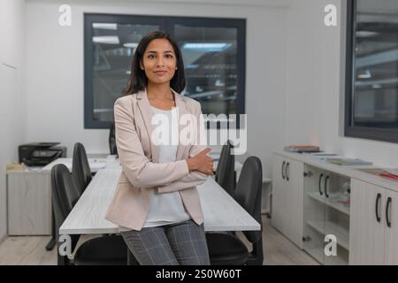 Portrait d'une jeune femme indienne prospère, PDG d'une entreprise industrielle dans son bureau. Emploi, carrière et concepts d'affaires. Banque D'Images