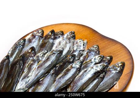 Poisson séché sur une plaque de céramique sur fond blanc. Sombre ou Shemaya. Eau très savoureuse et huileuse pour la bière. Banque D'Images