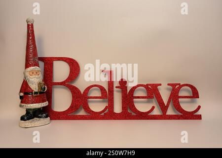 Le mot croire à côté de Santa clause avec un fond blanc propre Banque D'Images