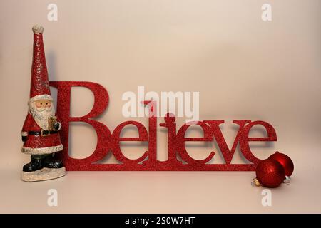 Le mot croire à côté de Santa clause avec un fond blanc propre Banque D'Images