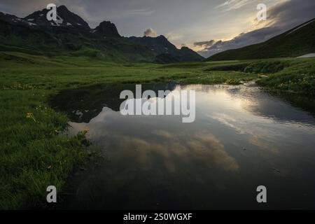 Sommet dans la lumière du matin avec des nuages dramatiques et ruisseau au premier plan, Lech, Lechquellengebirge, Vorarlberg, Autriche, Europe Banque D'Images