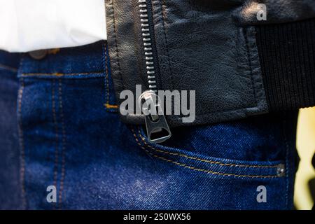 Gros plan d'une fermeture éclair en veste en cuir noir et Jean bleu Banque D'Images