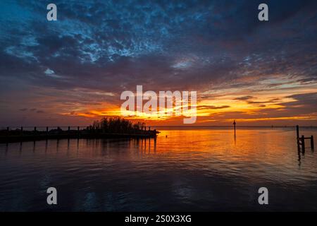 Coucher de soleil sur Mobile Bay à Fairhope, Alabama. Les couchers de soleil brillants sont fréquents à travers les eaux de Mobile Bay dans le sud de l'Alabama. Fairhope Marina est sur Banque D'Images