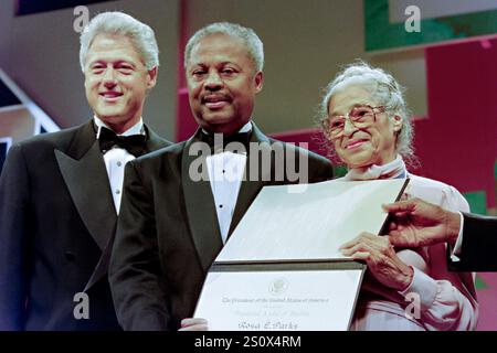 Le président américain Bill Clinton, à gauche, pose avec la militante des droits civiques Rosa Parks, à droite, et le président du Black Caucus du Congrès, Rep. Donald Payne, au centre, après avoir remis à Parks la Médaille de la liberté lors du 26e dîner de gala annuel, septembre 14,1996 à Washington, DC Parks, connue sous le nom de « première dame de la droite civile », a joué un rôle central dans le boycott des bus de Montgomery en 1943. Banque D'Images