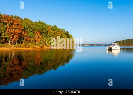 Un catamaran Endeavour Power est ancré dans les eaux tranquilles d'une crique sur le lac Bay Springs sur la rivière Tennessee Tombigbee dans le Mississippi en automne Banque D'Images