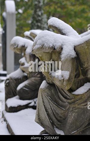 Manteaux de neige frais sculptures d'anges sur une tombe au cimetière historique notre-Dame-des-Neiges de Montréal. Banque D'Images