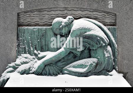 De la neige fraîche recouvre une sculpture sur une tombe du cimetière historique notre-Dame-des-Neiges de Montréal. Banque D'Images