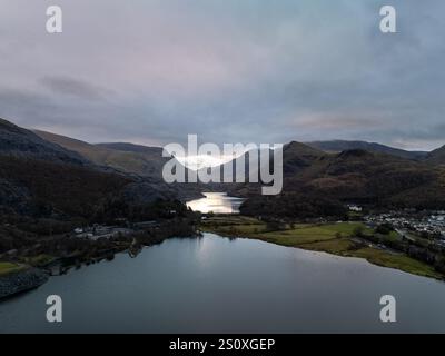 Vue aérienne du lac Llyn Padarn reflétant le ciel nuageux au coucher du soleil avec des montagnes en arrière-plan, Snowdonia National Park, pays de Galles Banque D'Images