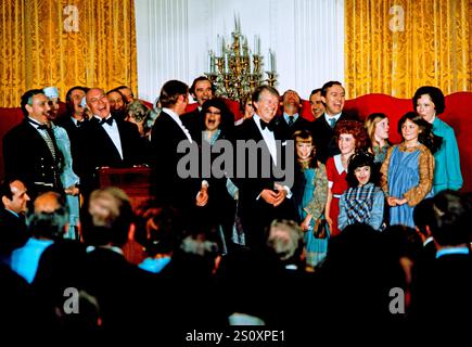 Le président des États-Unis Jimmy carter, au centre, la première dame Rosalynn carter, à droite, pose avec le casting de « Annie » alors qu’ils organisent un dîner en l’honneur des gouverneurs des États et de leurs conjoints dans la salle est de la Maison Blanche à Washington, DC le mardi 1er mars 1977. Crédit : Arnie Sachs/CNP Banque D'Images