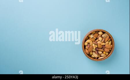 Noix mélangées composées de noix de cajou, noisettes, amandes et pistaches dans un bol en bois Banque D'Images