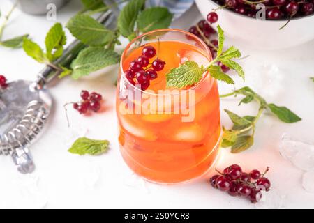 Red Currant Caipirinha, limonade ou boisson de sangria avec des glaçons et du jus de citron vert, sur un espace de copie de fond de table de cuisine blanc Banque D'Images