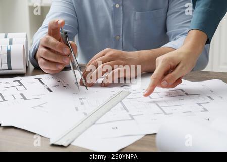 Architectes travaillant avec le projet, gros plan. Différents dessins techniques sur table en bois Banque D'Images