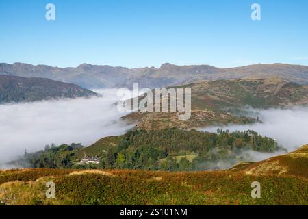 Un matin ensoleillé et lumineux sur Loughrigg est tombé avec une inversion de nuages créant une couche de brume sous les puits dans cet emplacement Lake District. Banque D'Images