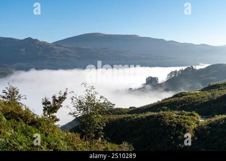 Un matin ensoleillé et lumineux sur Loughrigg est tombé avec une inversion de nuages créant une couche de brume sous les puits dans cet emplacement Lake District. Banque D'Images