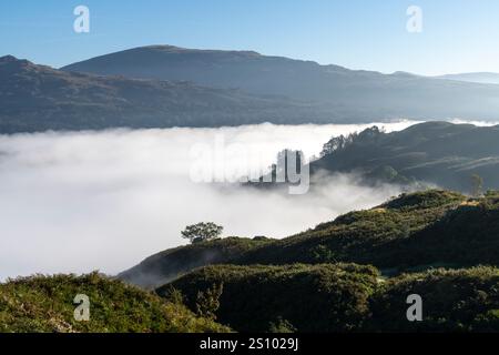 Un matin ensoleillé et lumineux sur Loughrigg est tombé avec une inversion de nuages créant une couche de brume sous les puits dans cet emplacement Lake District. Banque D'Images