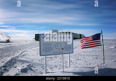 Pôle Sud géographique de la Terre en Antarctique. Panneau avec une carte du pôle Sud et un drapeau américain est affiché sur un poteau. Région Antarctique in Banque D'Images