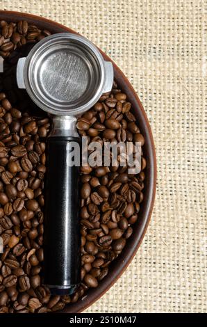 Cône de café et grains de café sur une plaque de céramique sur un fond de toile de jute. Banque D'Images