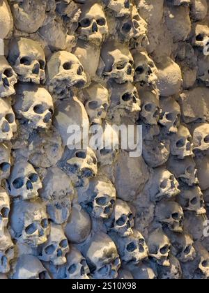 Un mur de crânes simulés dans le Musée de la torture dans la ville médiévale fortifiée de San Gimignano, en Italie. Banque D'Images