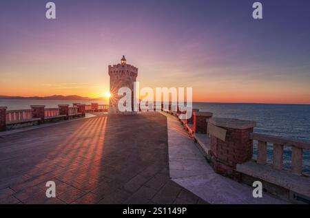 Coucher de soleil sur le phare Piombino piazza Bovio et l'île d'Elbe en arrière-plan. Région Toscane, Italie Banque D'Images