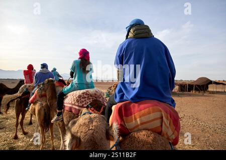 touristes sur une expérience de balade à dos de chameau à douar bou azza maroc Banque D'Images