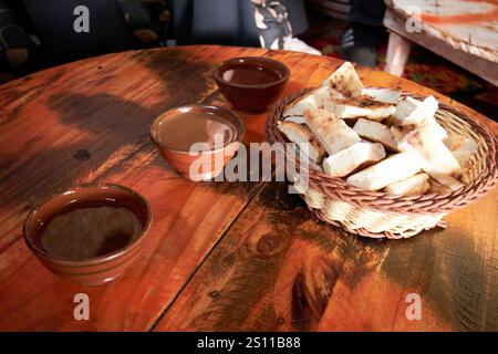 petit-déjeuner berbère traditionnel d'huile d'argan, amlou, huile d'argan et miel se mélangent avec du pain dans le collectif d'argan pour femmes dans une boue traditionnelle et de bois encadrés b Banque D'Images