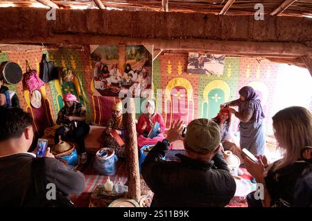touristes visitant un collectif d'argan pour femmes dans une maison berbère traditionnelle à ossature de boue et de bois à azrou maroc Banque D'Images