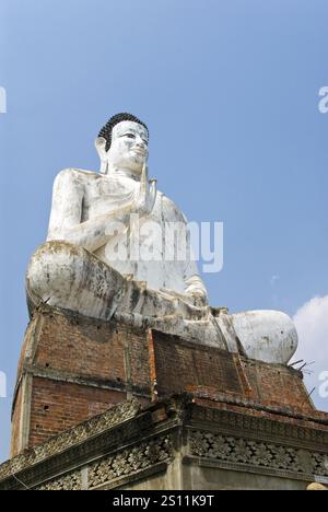 Une très grande statue de Bouddha se dresse près d'un étang à Wat Ek Phnom, un temple atmosphérique, partiellement ruiné du XIe siècle, à 11 km au nord de Battambang, au Cambodge. Banque D'Images