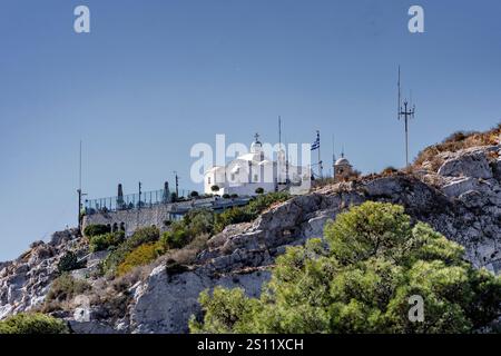 Athènes, Attique - GR - Oct 26, 2024 L'église Saint-Georges au sommet du mont Lycabette, une chapelle blanchie à la chaux avec un drapeau grec, entourée de rudes Banque D'Images