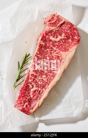 Steak Wagyu cru frais australien sur la surface de la table de cuisine ensoleillée claire, vue de dessus Banque D'Images
