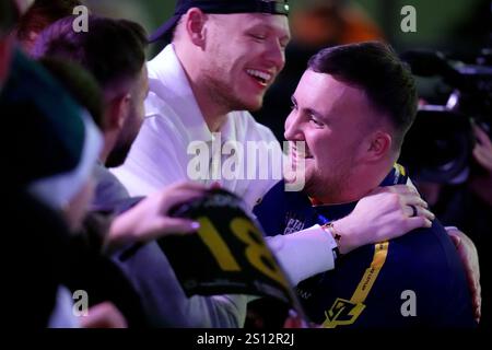 Luke Littler est félicité pour sa victoire par le gardien de Southampton Aaron Ramsdale après avoir battu Ryan Joyce lors de la treizième journée du Championnat du monde de fléchettes Paddy Power à Alexandra Palace, Londres. Date de la photo : lundi 30 décembre 2024. Banque D'Images