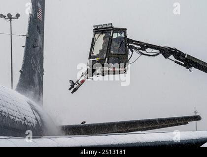 Un gardien affecté au 171st maintenance Group utilise un véhicule de dégivrage pour souffler la neige d'un avion KC-135 Stratotanker Dec. 20, 2024, à la 171st Air ravitaillement Wing près de Pittsburgh, Pennsylvanie. L'avion doit être dégagé de neige et de glace avant le décollage. (Photo de la U.S. Air National Guard par Tech. Sgt. Zoe M. Wockenfuss) Banque D'Images
